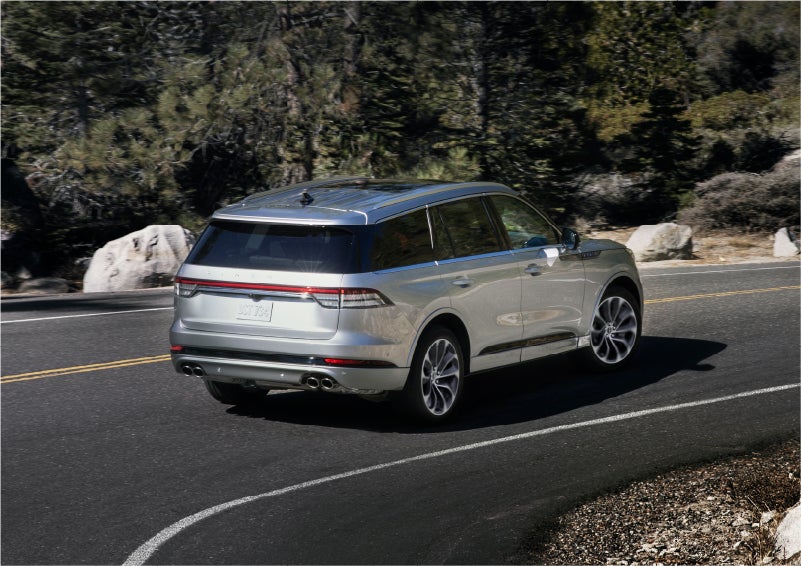 A 2023 Lincoln Aviator® Grand Touring model is shown being driven on a tight turn of a mountain road | Gary Yeomans Lincoln Ocala in Ocala FL