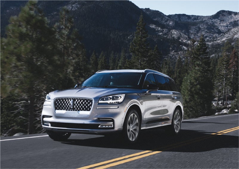 A 2023 Lincoln Aviator® Grand Touring SUV being driven on a winding road to demonstrate the capabilities of all-wheel drive | Gary Yeomans Lincoln Ocala in Ocala FL